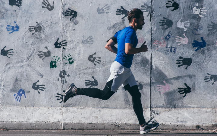Hombre corriendo al aire libre, practicando deporte y ejercicio para mantenerse en forma.