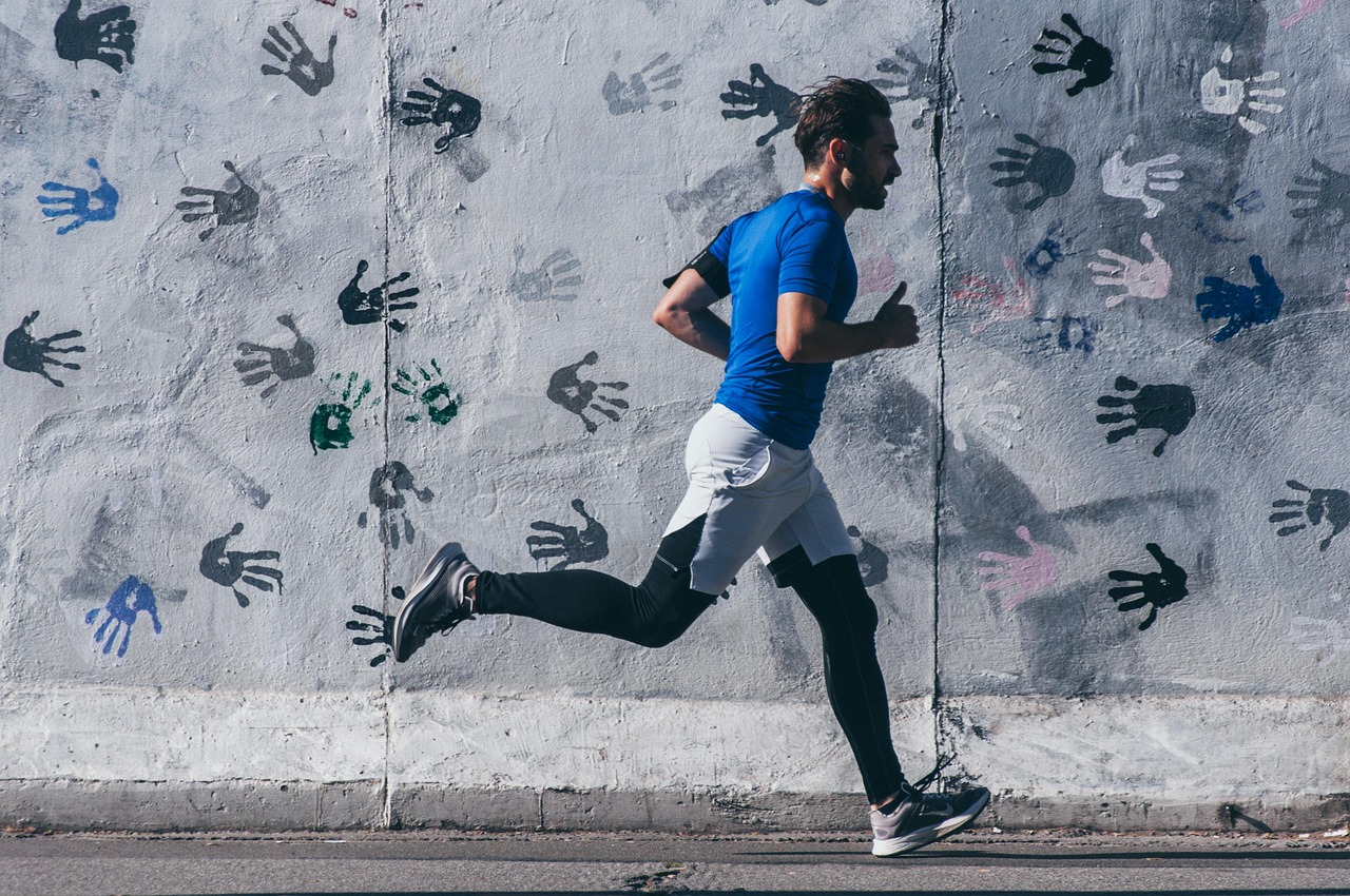 Hombre corriendo al aire libre, practicando deporte y ejercicio para mantenerse en forma.