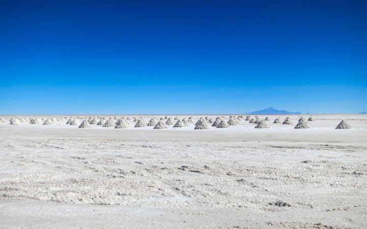 Salar con costra blanca de sal bajo un cielo azul en un paisaje árido de los Andes. Se parece a un desierto de sal.