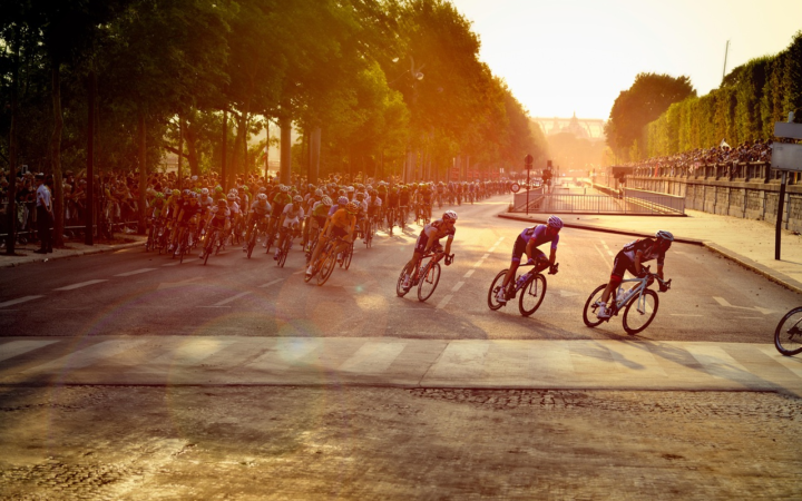 Ciclistas compitiendo en una etapa del Tour de Francia en París, en plena carrera de velocidad y movimiento.