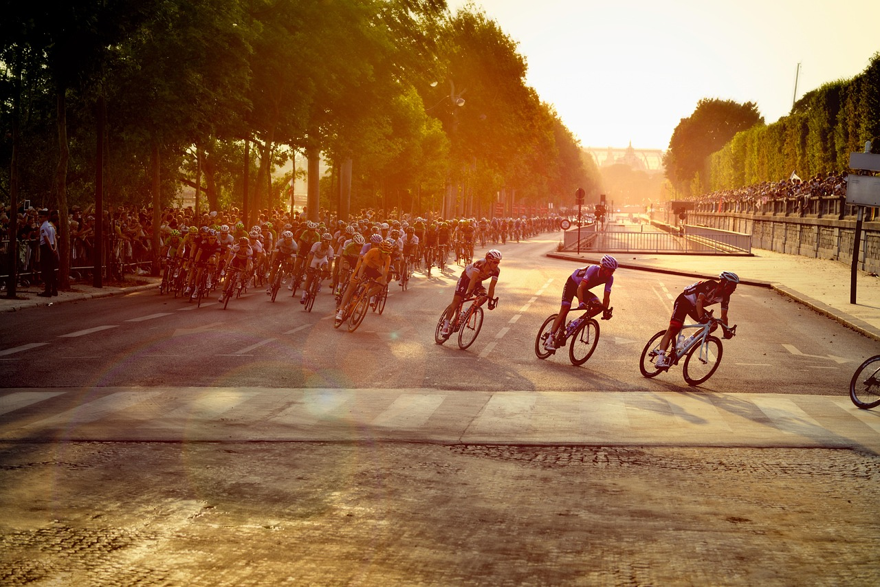 Ciclistas compitiendo en una etapa del Tour de Francia en París, en plena carrera de velocidad y movimiento.