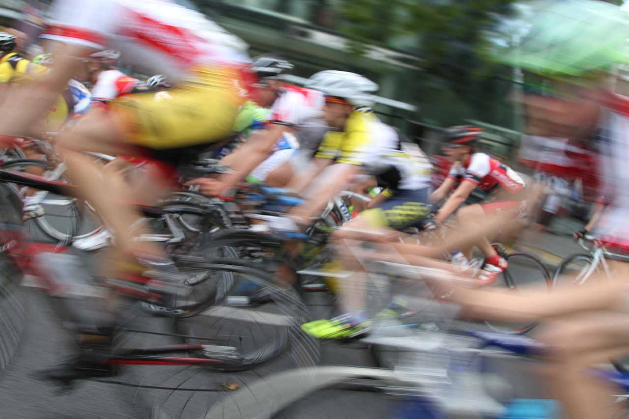 Grupo de ciclistas en una carrera de bicicleta de ruta, compitiendo a alta velocidad como equipo.