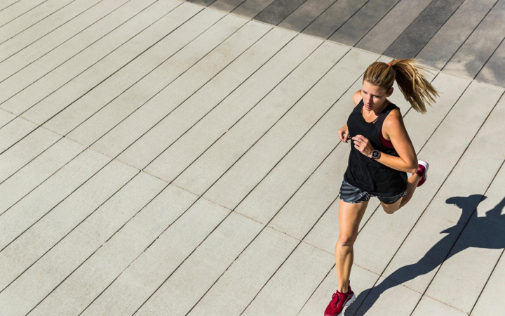 Mujer corriendo al aire libre, en una imagen que transmite actividad física, ejercicio y estilo de vida saludable.
