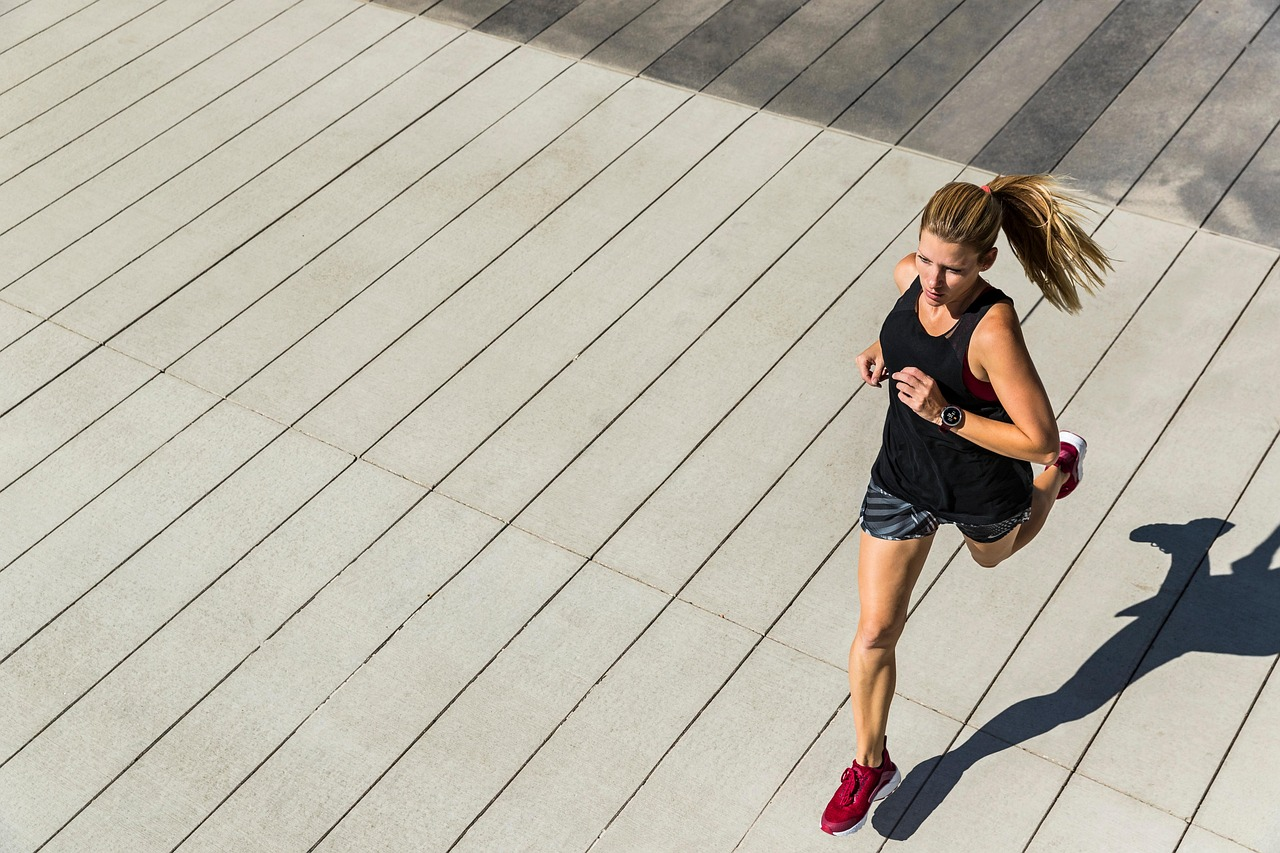 Mujer corriendo al aire libre, en una imagen que transmite actividad física, ejercicio y estilo de vida saludable.