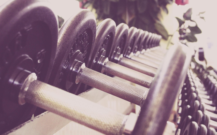 Mancuernas y pesas en un gimnasio, con equipo de entrenamiento de fuerza dispuesto en un estudio de acondicionamiento físico.