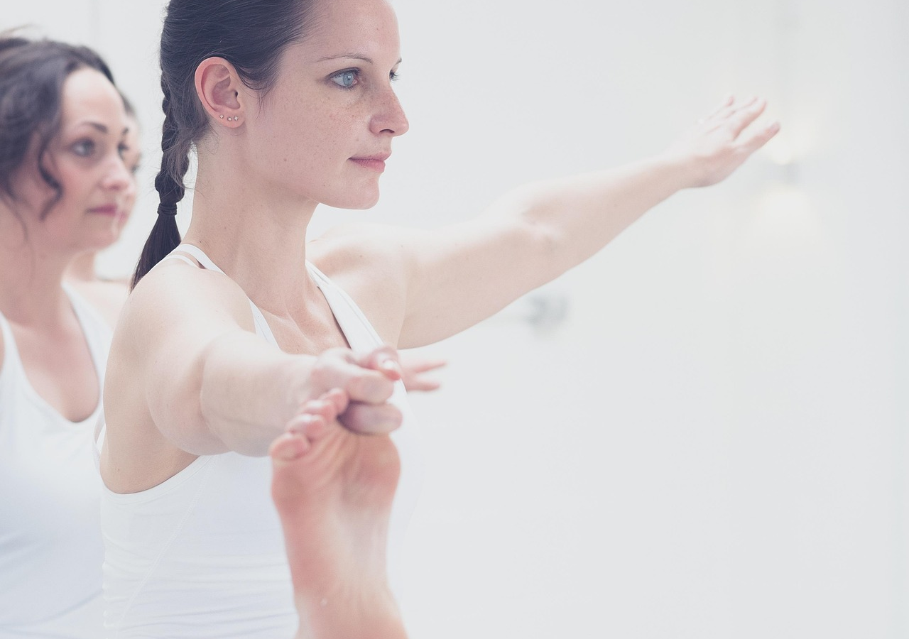 Mujer joven haciendo una pose de yoga y estiramiento, en un ambiente de bienestar y vida activa.
